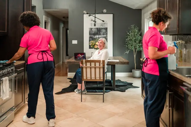 Molly Maid professionals providing kitchen cleaning for a senior customer. 